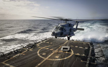 Military Sikorsky SH-60 Seahawk helicopter hovering over the deck of a naval ship at sea, captured in 4K Ultra HD quality as a detailed PC desktop wallpaper.