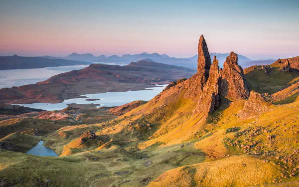 HD PC desktop wallpaper showcasing a panoramic nature landscape with rugged rock formations overlooking a tranquil lake under a soft, colorful sky.