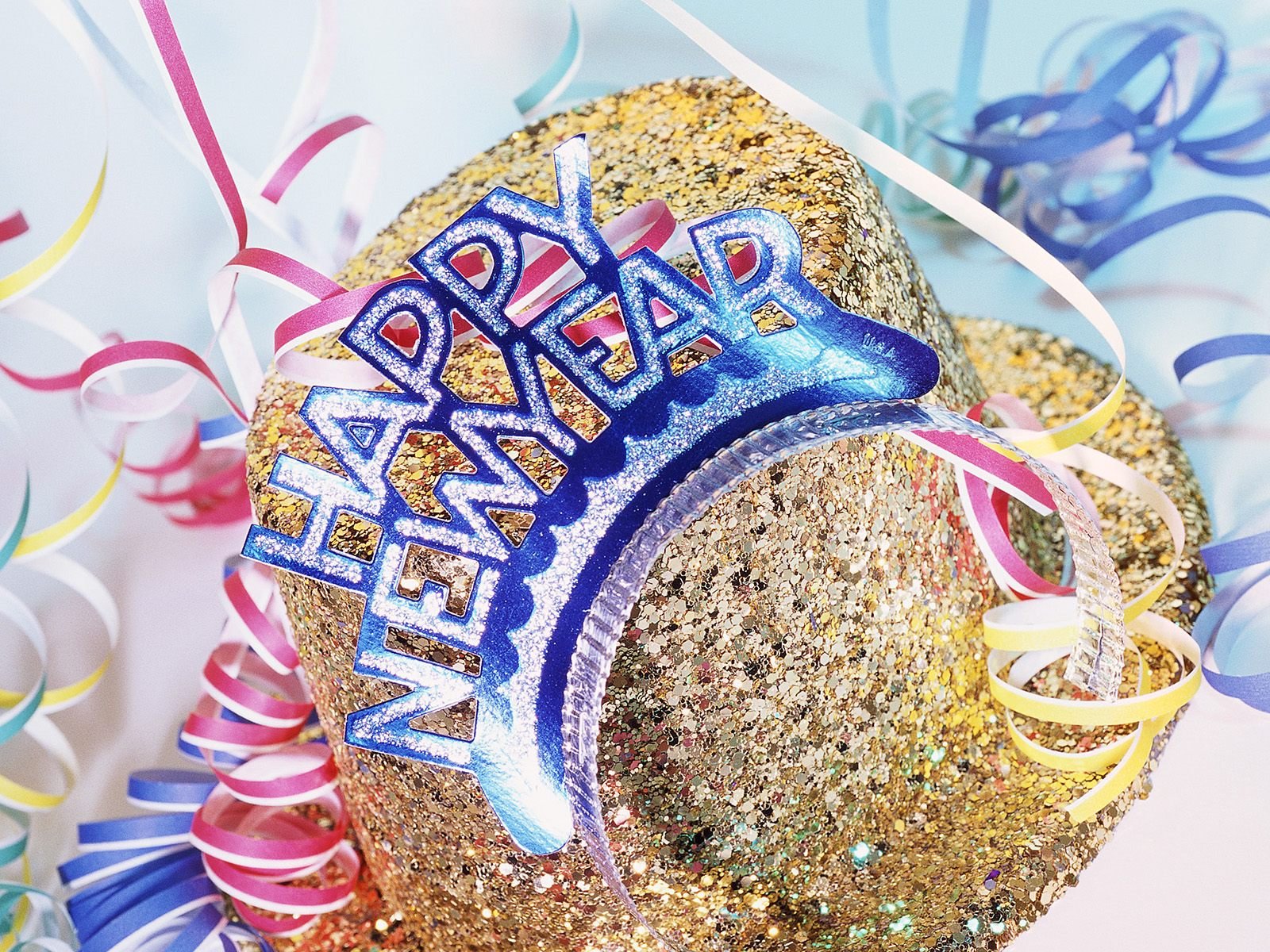HD PC desktop wallpaper featuring a glittery Happy New Year headband surrounded by colorful holiday streamers, capturing festive New Year celebrations.