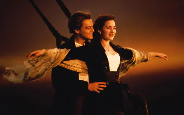HD wallpaper featuring Leonardo DiCaprio and Kate Winslet in an iconic scene from the movie Titanic, with the characters embracing on the ship's bow.