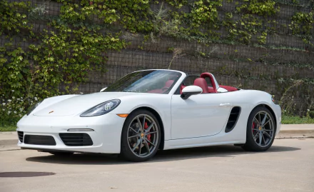 White Porsche 911 convertible with red interior parked against a stone wall, showcased as an HD PC desktop wallpaper and background.