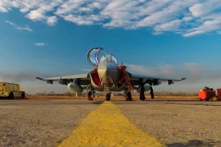 Front view of a Yakovlev Yak-130 military jet fighter warplane on a runway under a partly cloudy sky, captured in high-definition for a desktop wallpaper.