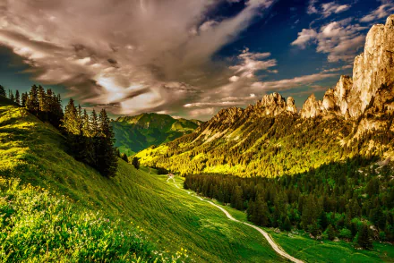 HD desktop wallpaper of a lush green valley path with rugged mountains, dramatic clouds, and vibrant sky, showcasing stunning natural scenery.
