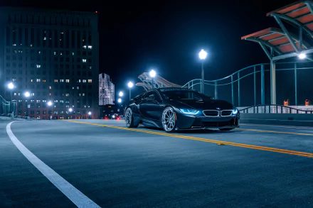 A sleek black BMW i8 supercar parked on a city street at night, captured in sharp detail as an 8K Ultra HD PC desktop wallpaper.