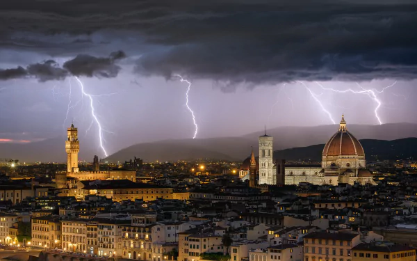Lightning bolts illuminate the night sky over Florence, Italy, highlighting the iconic dome and historic cityscape beneath dark storm clouds.