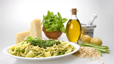 HD desktop wallpaper featuring a still life of pasta with pesto, cheese, olive oil, fresh basil, and ingredients arranged on a white background.