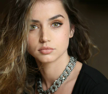 HD desktop wallpaper and background featuring Cuban actress Ana de Armas with green eyes and brunette hair, wearing a necklace.