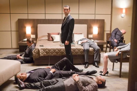 HD PC desktop wallpaper featuring Joseph Gordon-Levitt in a scene from the movie Inception, standing in a modern bedroom with several people lying around him.