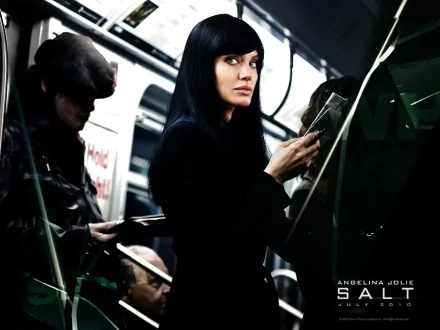 A dramatic scene from the movie Salt, featuring Angelina Jolie skillfully navigating a subway, exuding mystery and intrigue in an HD desktop wallpaper.