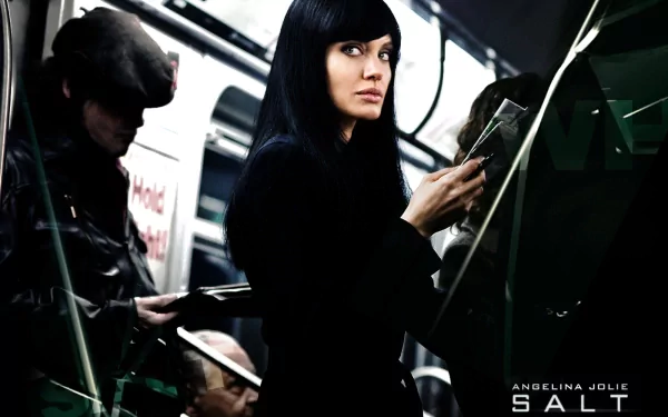 A dramatic scene from the movie Salt, featuring Angelina Jolie skillfully navigating a subway, exuding mystery and intrigue in an HD desktop wallpaper.