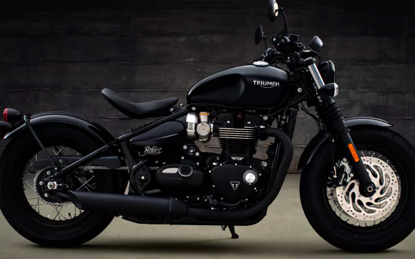 Black Triumph Bonneville motorcycle (vehicle) in side profile against a dark backdrop — 4K Ultra HD PC desktop wallpaper background.