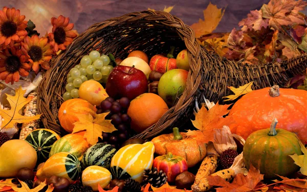 A vibrant fall still life featuring pumpkins, gourds, assorted fruits, and flowers arranged in a basket with autumn leaves, captured in HD for a PC desktop wallpaper.