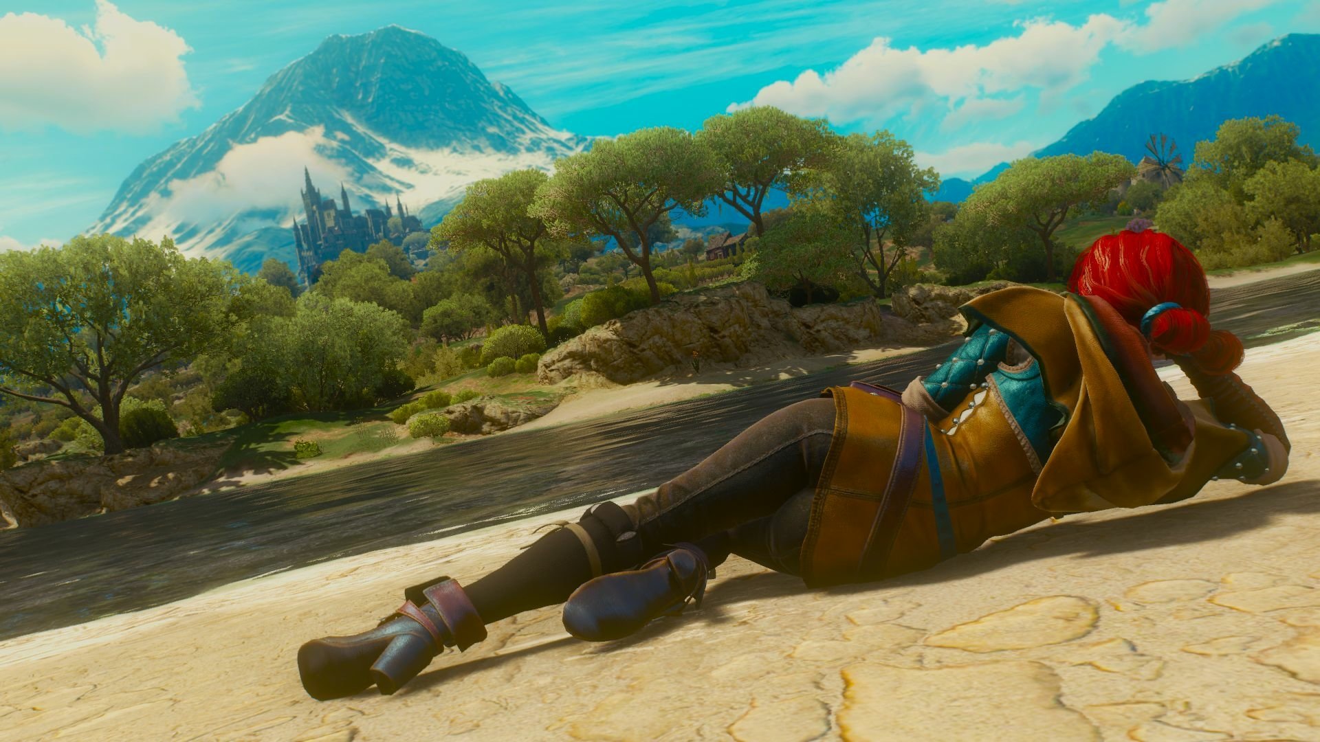 HD desktop wallpaper featuring Triss Merigold from The Witcher 3: Wild Hunt, lying on a riverbank with a scenic mountain and castle in the background.