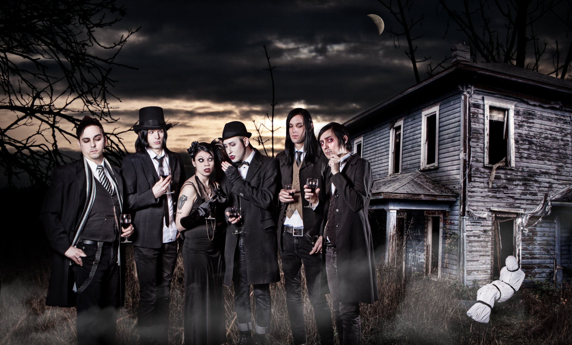 Moonlit gothic band portrait before a decrepit house, moody music-themed 2K Quad HD PC desktop wallpaper background.