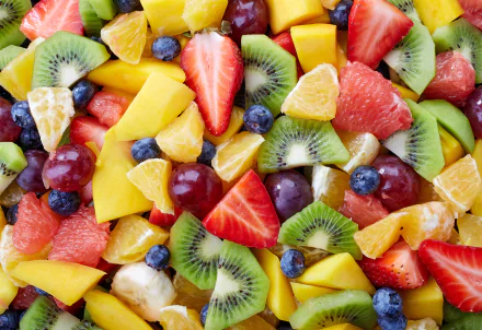 A vibrant 4K Ultra HD PC desktop wallpaper featuring a colorful assortment of fresh fruit slices including strawberries, kiwi, mango, blueberries, grapes, and citrus.
