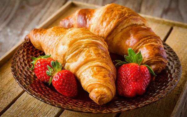 Close-up of golden croissants and fresh strawberries on a woven plate, captured in crisp 8K Ultra HD resolution as a vibrant breakfast viennoiserie scene.