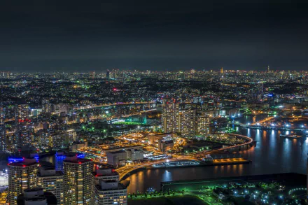 Nighttime cityscape of Yokohama, Tokyo, Japan, showcasing illuminated buildings and waterways in a vibrant, man-made urban environment.