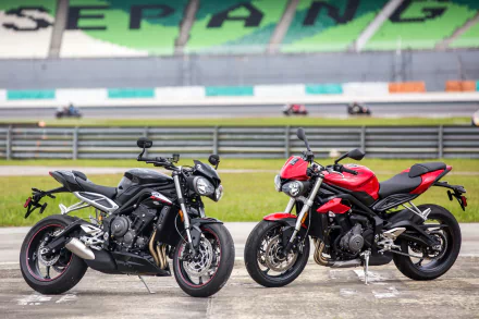 Two Triumph Street Triple motorcycles, one black and one red, parked side by side on a racetrack, featured in a 4K Ultra HD PC desktop wallpaper background.