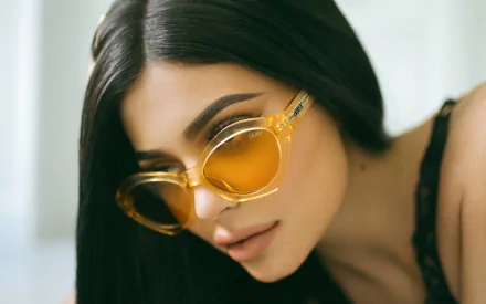 HD desktop wallpaper featuring a close-up of American brunette model and celebrity Kylie Jenner wearing stylish yellow sunglasses.
