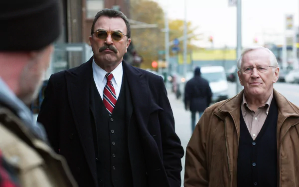 HD desktop wallpaper featuring two men from the TV series Blue Bloods, one in a suit and the other in a brown jacket, on a city street.