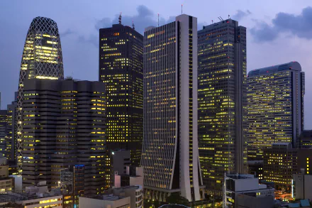 HD wallpaper of Shinjuku's skyscrapers at dusk with lights illuminating the buildings in Tokyo.