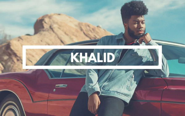 HD desktop wallpaper featuring a thoughtful individual leaning on a red car with a desert backdrop, tagged with Khalid.