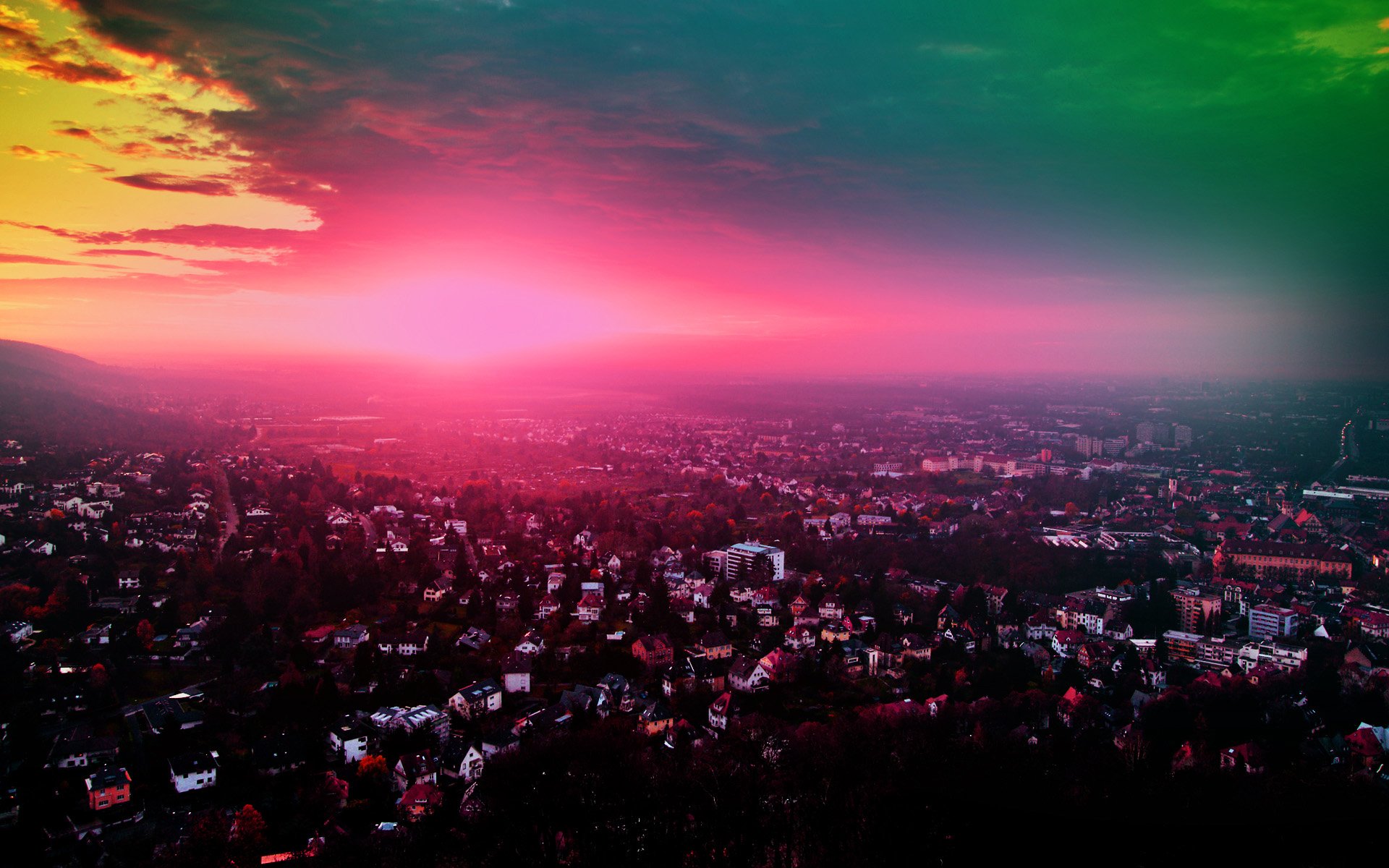 Artistic HD PC desktop wallpaper showcasing a sprawling cityscape under a vibrant, surreal sunset with pink and green hues blending into the sky.