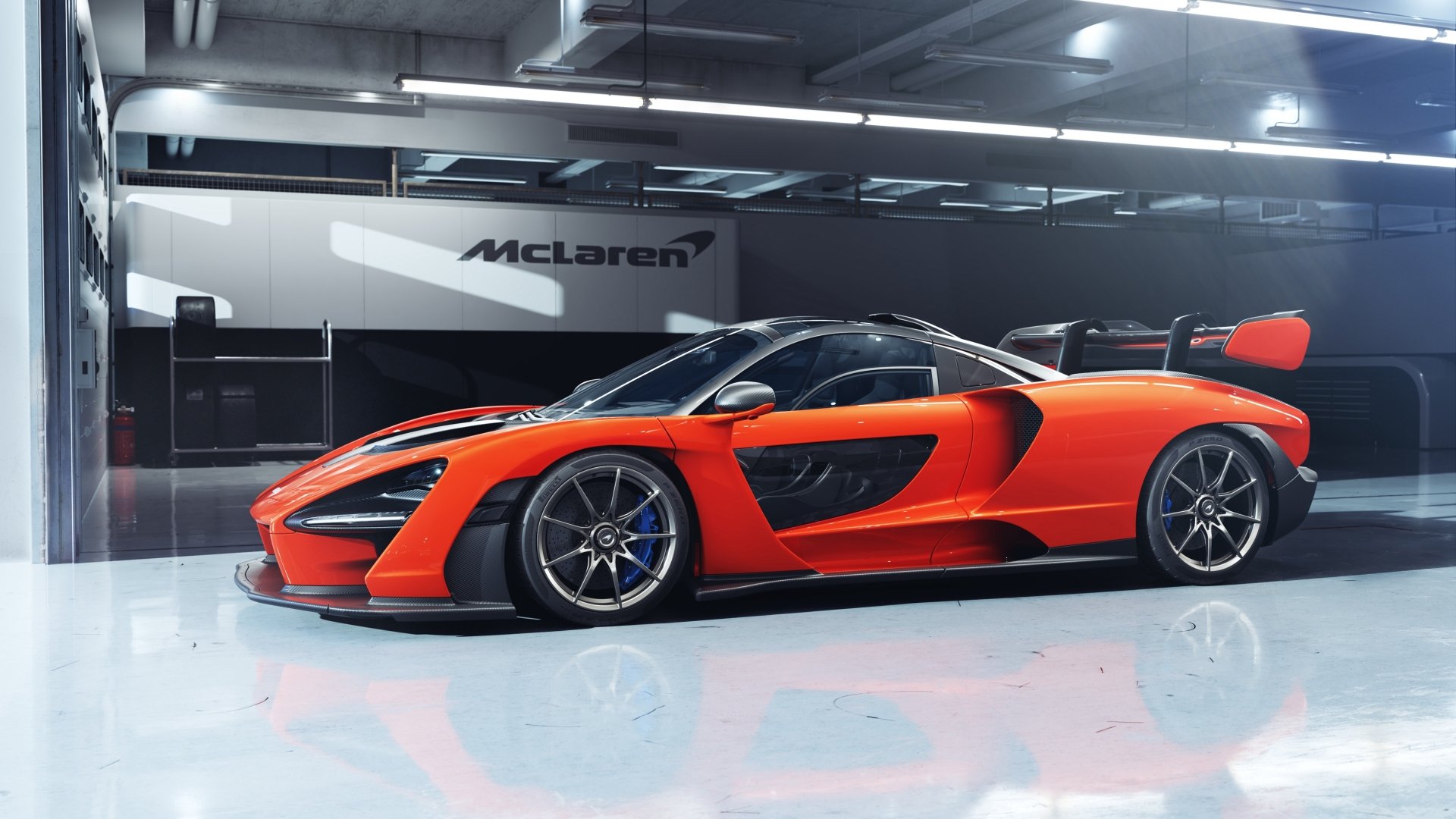 A vibrant orange McLaren Senna supercar showcased in a sleek, modern garage, captured in stunning 4K Ultra HD quality.