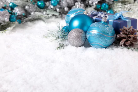 Christmas ornaments and blue gift boxes rest on snow, surrounded by pine cones and festive holiday decorations, presented in 4K Ultra HD desktop wallpaper quality.