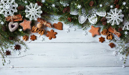 Holiday-themed HD desktop wallpaper featuring cinnamon sticks, pine cones, crocheted snowflake decorations, and festive cookies arranged on a rustic wooden background.