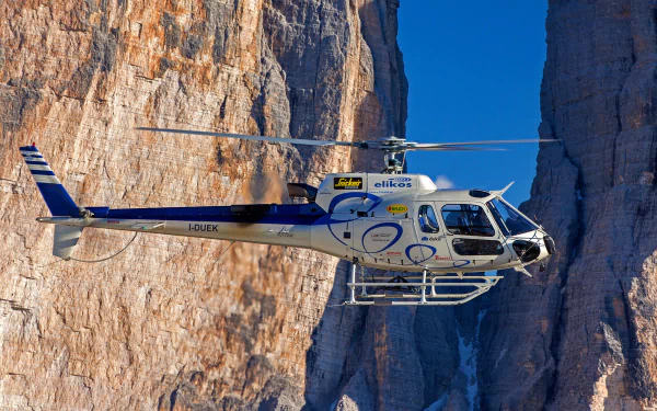 Eurocopter AS350 Écureuil helicopter flying between rugged cliffs, captured in HD for a detailed PC desktop wallpaper and background.