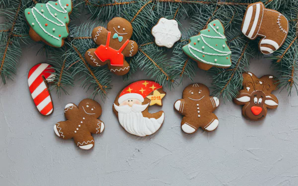 4K Ultra HD desktop wallpaper featuring Christmas-themed gingerbread cookies shaped like Santa, trees, candy cane, snowflake, and reindeer on pine branches.