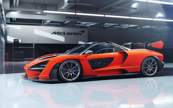 A vibrant orange McLaren Senna supercar showcased in a sleek, modern garage, captured in stunning 4K Ultra HD quality.