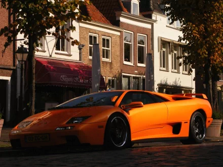 Orange Lamborghini Diablo parked on a street in front of historic buildings, showcased as an HD PC desktop wallpaper and background.