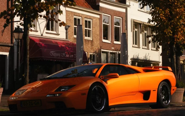 Orange Lamborghini Diablo parked on a street in front of historic buildings, showcased as an HD PC desktop wallpaper and background.