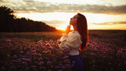 2K Quad HD PC desktop wallpaper: model woman in profile amid a purple flower field at sunset, warm backlight and shallow depth of field creating a moody atmosphere.