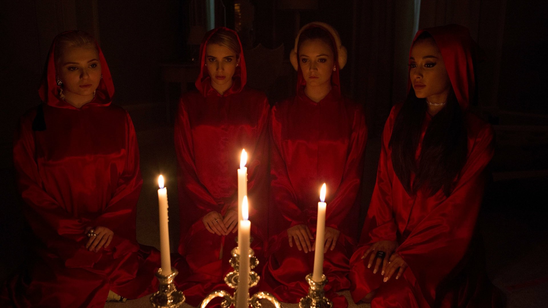 Ariana Grande with three other women in red robes sitting around lit candles, from the TV show Scream Queens, displayed in 4K Ultra HD for a PC desktop wallpaper.