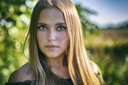 HD PC desktop wallpaper: close-up portrait of a blonde woman model with green eyes, shallow depth of field focusing on her face against a softly blurred outdoor background.