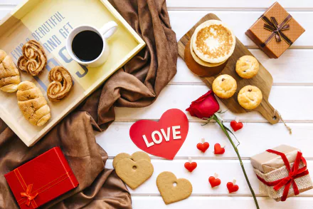 A 4K Ultra HD still life of viennoiserie, coffee, heart-shaped cookies, and Valentine’s Day gifts arranged on a white wooden surface, evoking love and holiday warmth.
