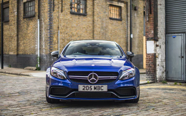 Front view of a blue Mercedes-Benz C-Class car parked on a cobblestone street, featured as a 4K Ultra HD PC desktop wallpaper and background.