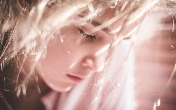 Close-up of a sunny, softly lit woman’s face with delicate highlights, captured in a 4K Ultra HD wallpaper featuring a serene model portrait.