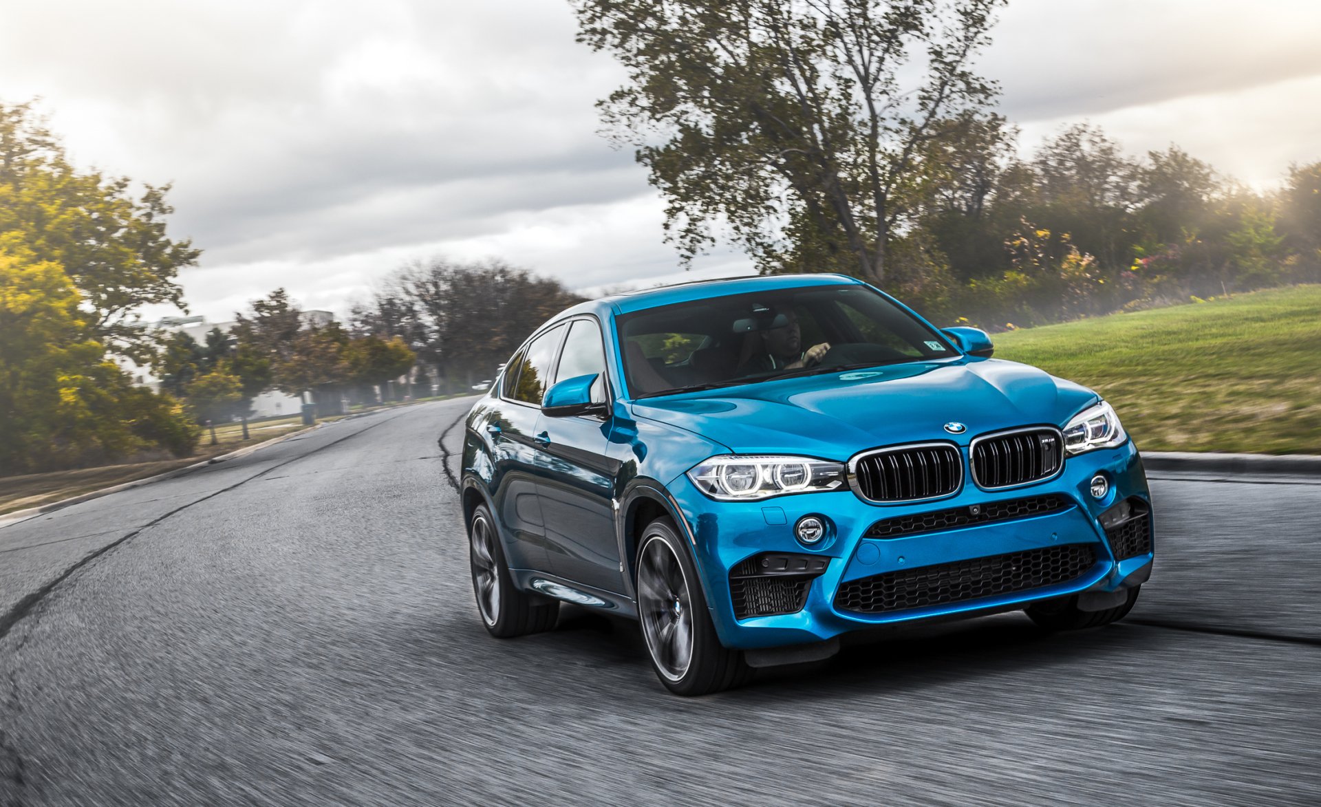 Blue BMW X6 car driving on a wet road at speed, dynamic angle — HD PC desktop wallpaper/background featuring a sporty BMW vehicle.