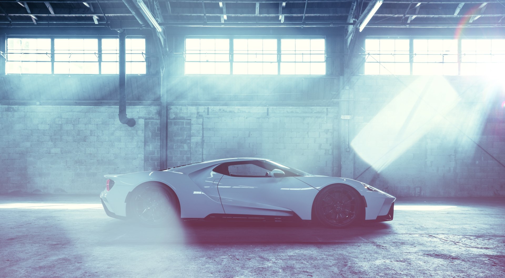 White Ford GT supercar showcased in a spacious, light-filled industrial warehouse, presented as an 8K Ultra HD PC desktop wallpaper and background.