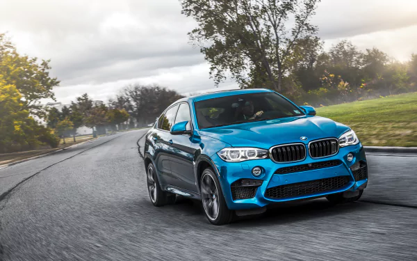 Blue BMW X6 car driving on a wet road at speed, dynamic angle — HD PC desktop wallpaper/background featuring a sporty BMW vehicle.