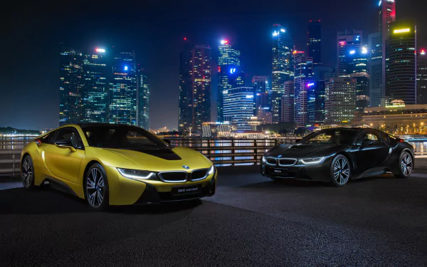 Two BMW i8 supercars, one yellow and one black, parked at night with a brightly lit city skyline in the background. 4K Ultra HD desktop wallpaper.