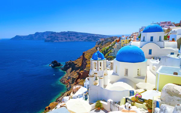 A stunning 4K Ultra HD view of Santorini, Greece, showcasing iconic white houses with blue domes perched on cliffs overlooking the deep blue sea.