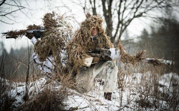 A soldier in winter camouflage gear with a sniper rifle blends into snowy, wooded terrain, highlighting military precision and stealth in a high-definition desktop wallpaper.