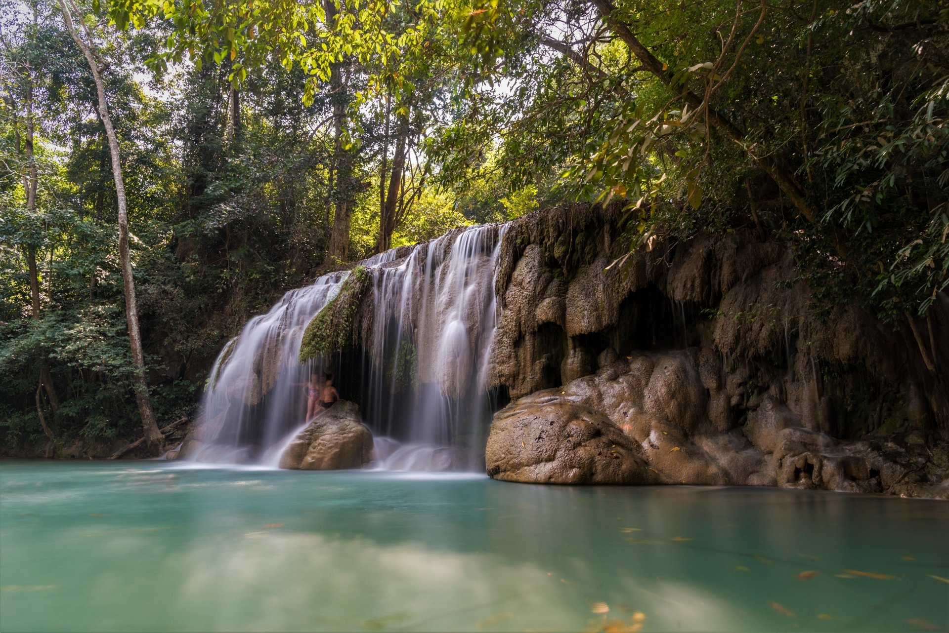 4K Ultra HD wallpaper of a serene tropical waterfall in a lush forest in Thailand, with clear turquoise water surrounded by dense greenery.