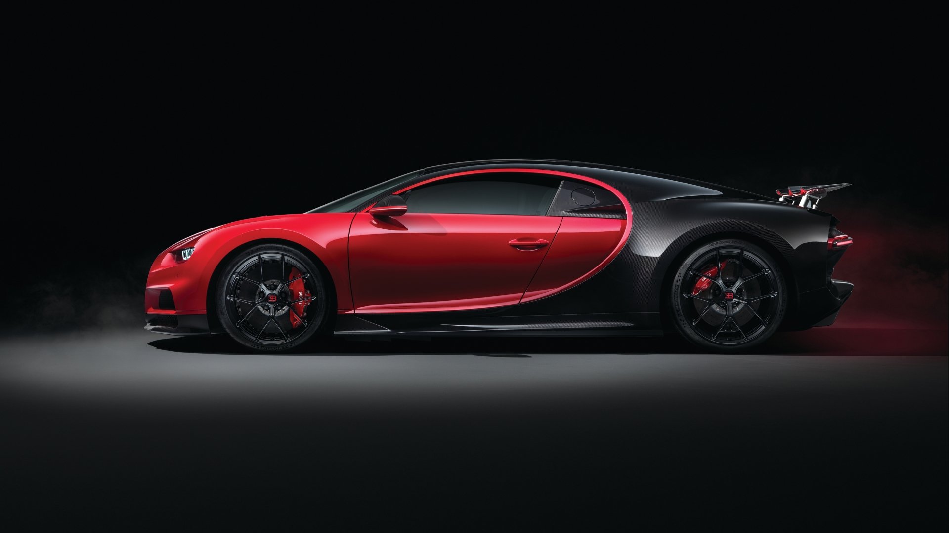 Sleek Bugatti Chiron supercar in red and black, showcased in a high-resolution 4K Ultra HD wallpaper emphasizing its bold design and performance.