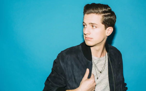 HD desktop wallpaper and background featuring a man in a dark jacket over a teal backdrop.